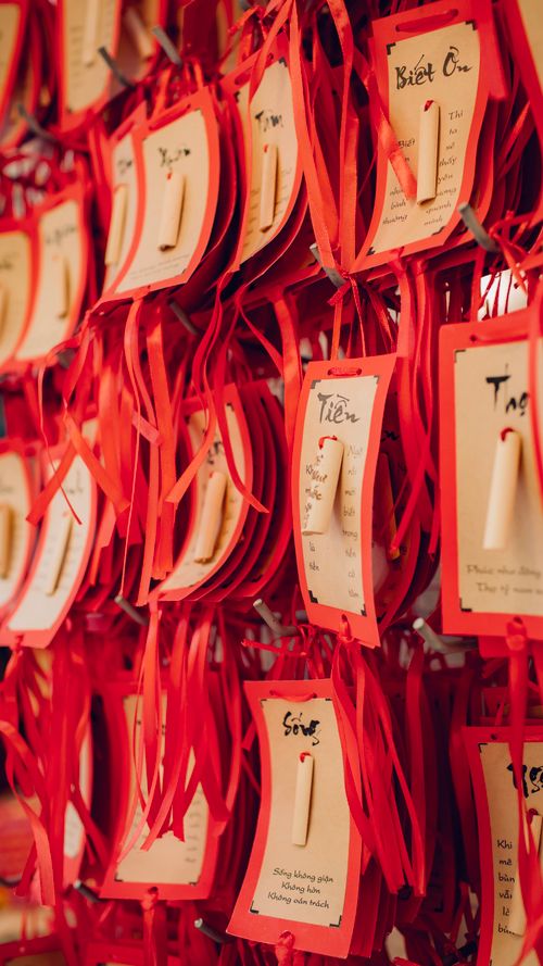 Free Red calligraphy cards with traditional Vietnamese text hanging on display. Stock Photo