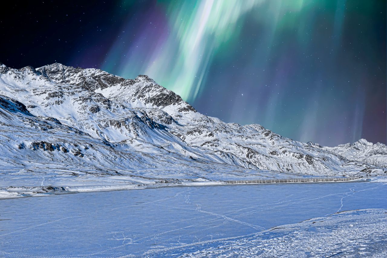 a stunning winter scene with snowcapped mountains and the aurora borea