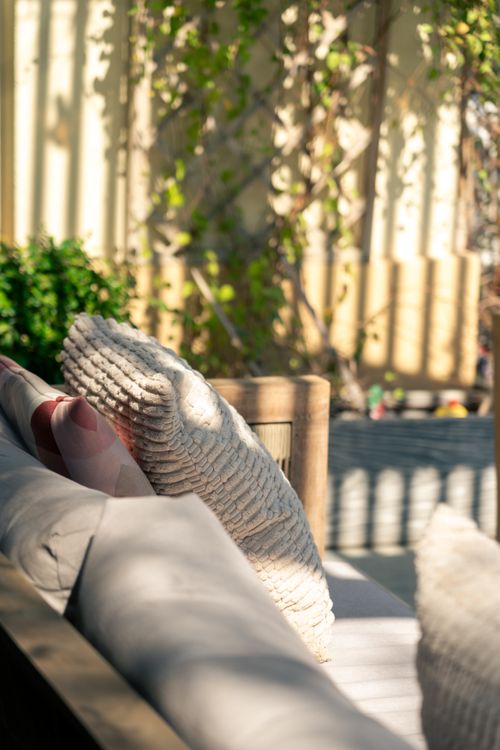 Free Sunny outdoor seating area with textured pillows in Dubai, UAE. Stock Photo