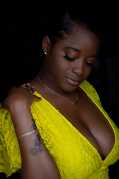 African woman in stylish yellow dress, expressing elegance and confidence.