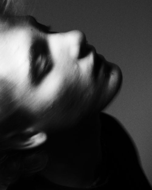Free Artistic side profile portrait of a young adult in moody black and white lighting. Stock Photo