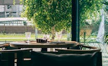 餐厅餐桌位于大窗旁，窗外郁郁葱葱的绿植让整个空间显得格外明亮迷人