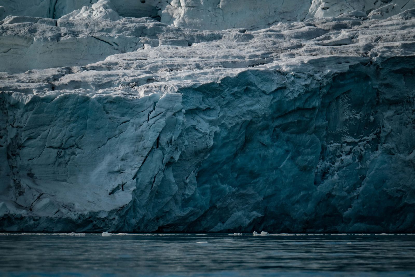 A wall of glacial ice above still polar water — photo by Francesco Ungaro on Pexels