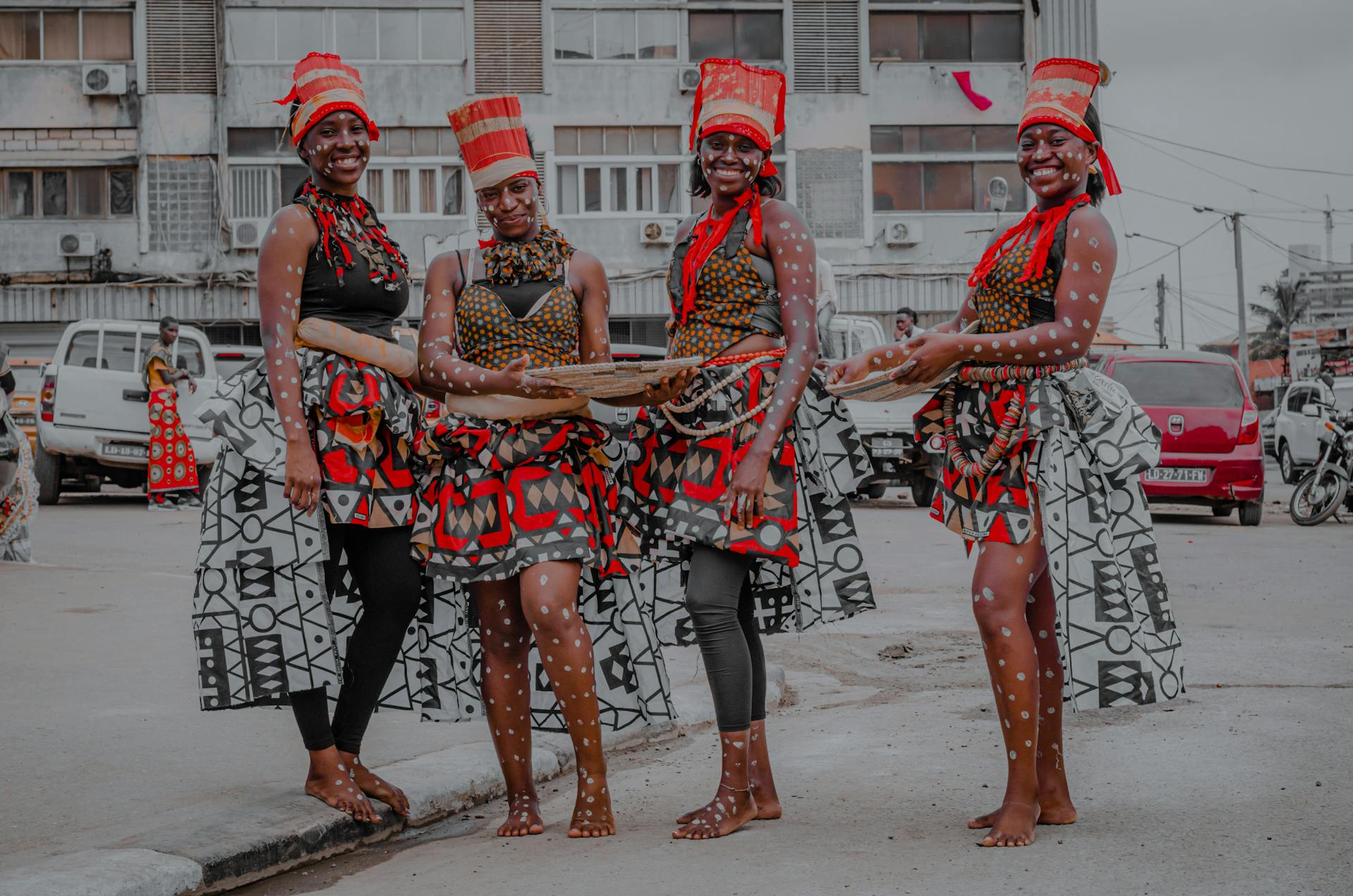 Four women in traditional Angolan attire performing a cultural dance in the streets of Luanda, Angola.