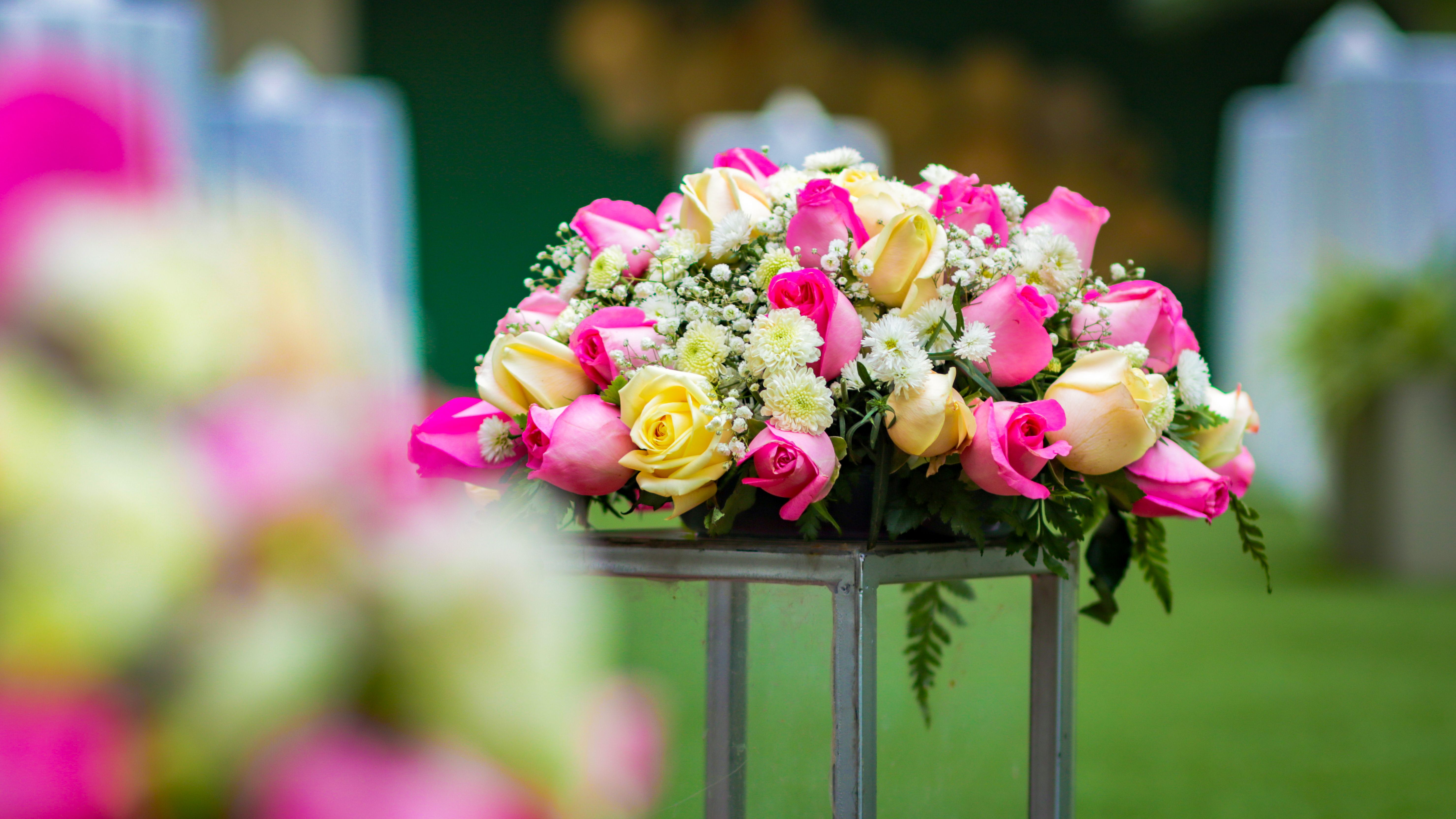 [ColoSach]-a-colorful-bouquet-of-pink-and-yellow-roses-arranged-beautifully-on-a-metal-stand-outdoors.