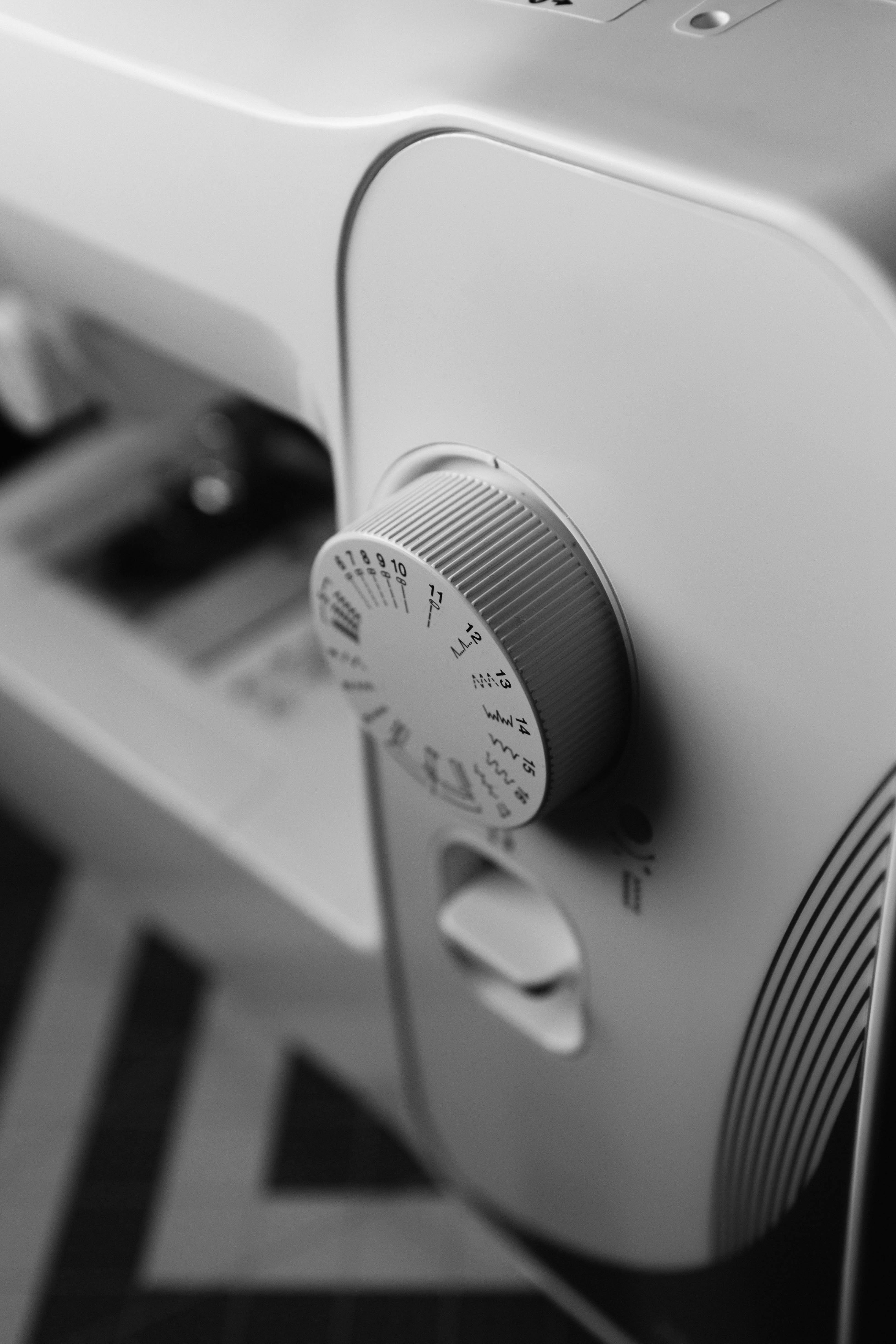 grátis Imagem detalhada em preto e branco de uma máquina de costura com foco no mostrador. Foto profissional