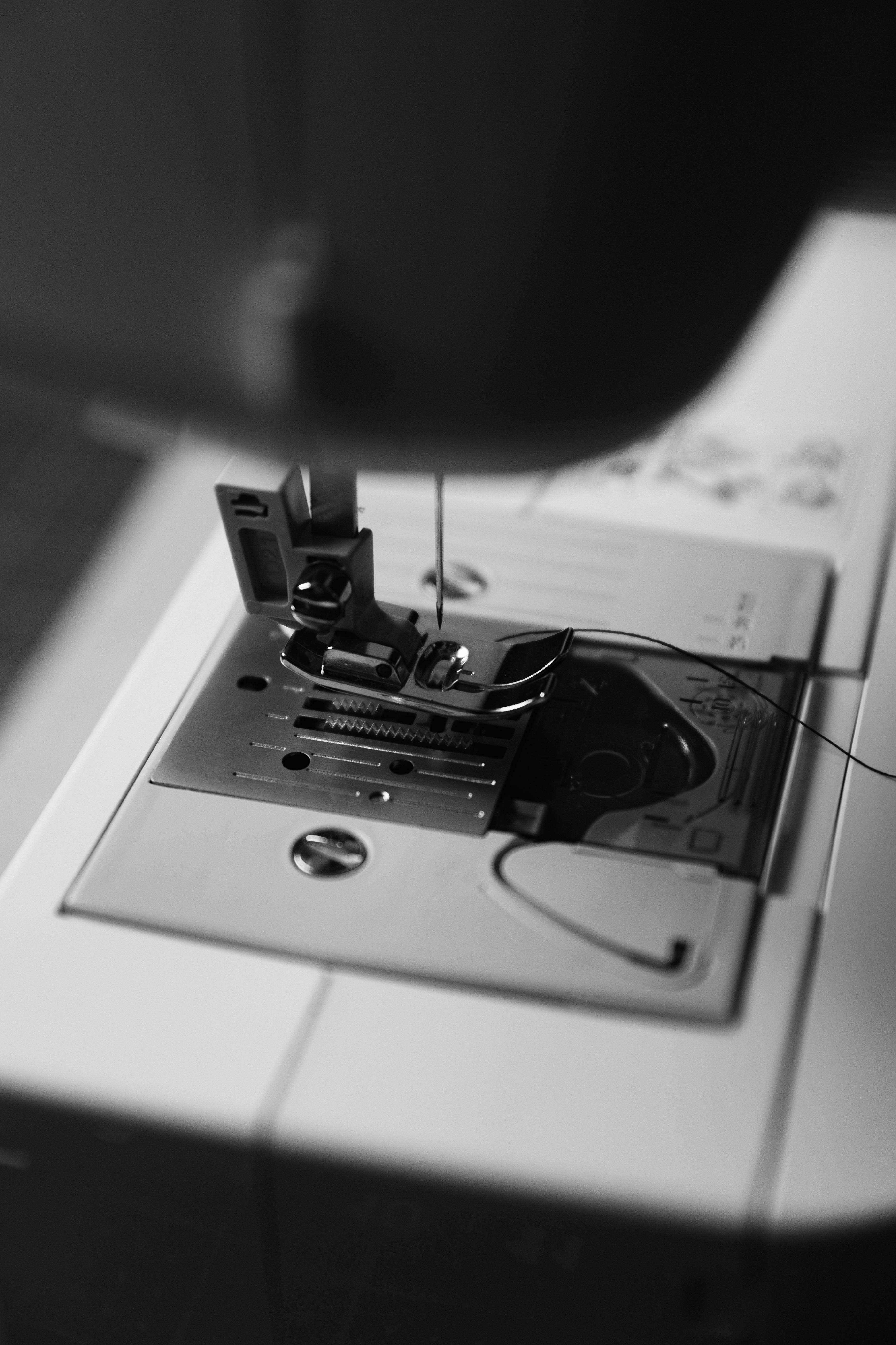 grátis Imagem detalhada em preto e branco da área da agulha de uma máquina de costura. Foto profissional