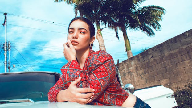 一位时尚女性在棕榈树下的古董车旁摆姿势