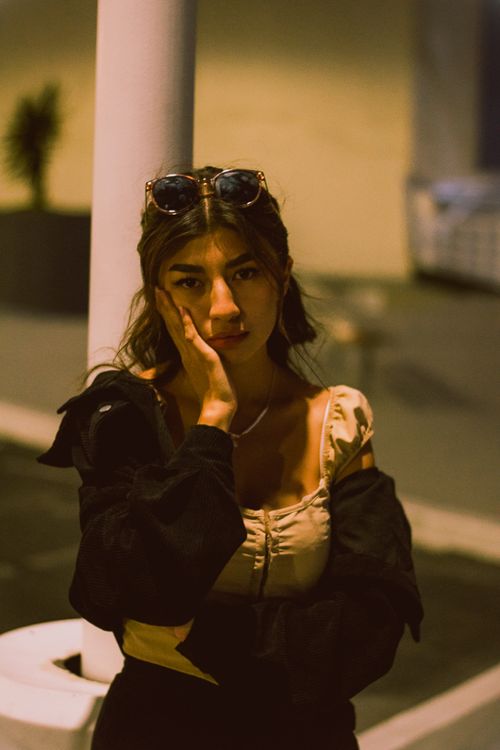 Free Stylish woman with sunglasses poses thoughtfully at night. Stock Photo