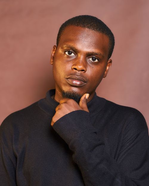 Free A pensive man poses against a neutral brown backdrop, exuding contemplation. Stock Photo