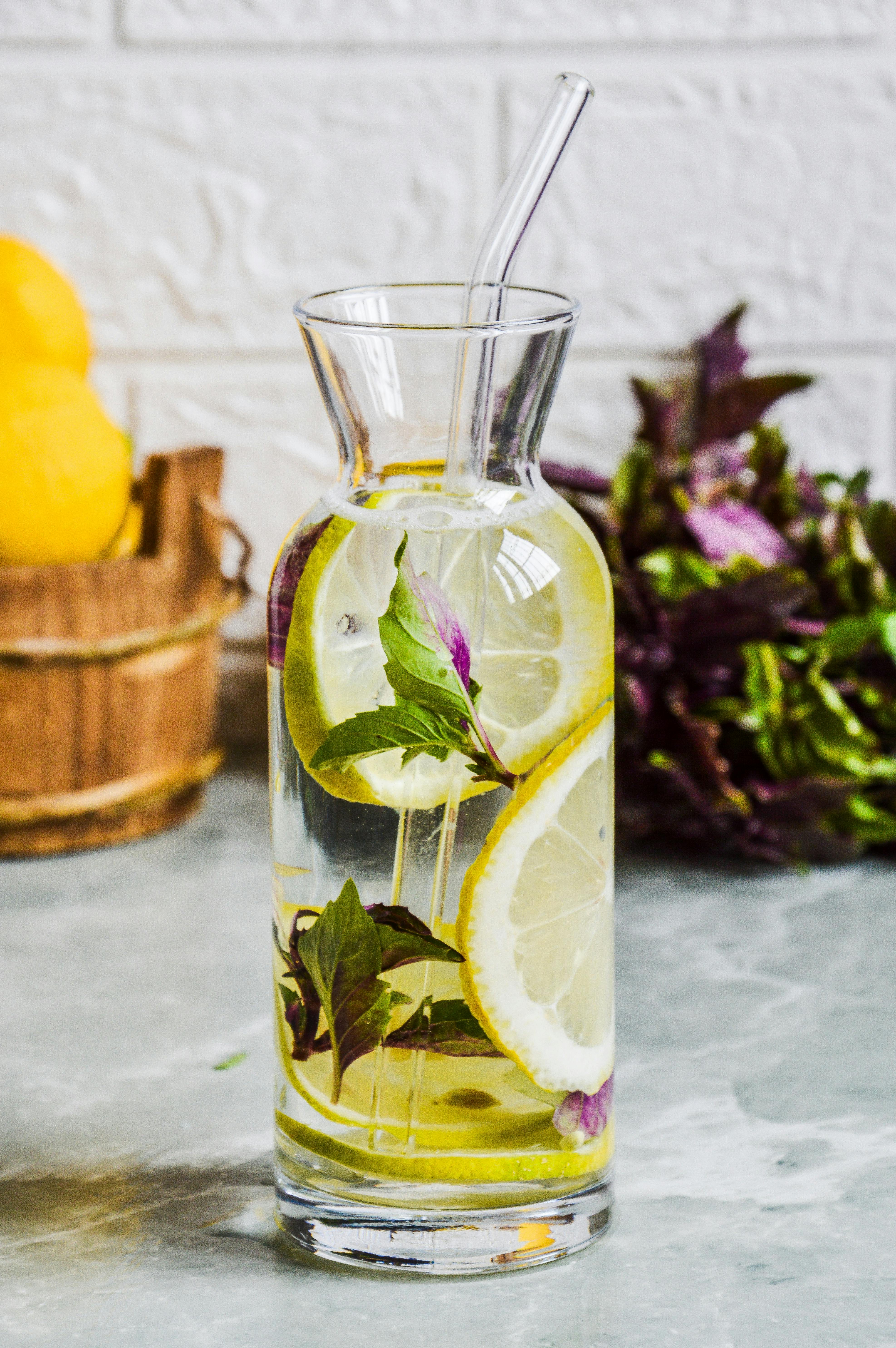 A vibrant glass of lemon and basil infused water, perfect for hydration.