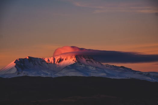 Captivating sunrise over snow-capped Erciyes Mountain with dramatic pink clouds.