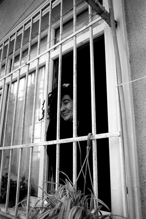 Free Black and white portrait of a woman smiling through a window in Istanbul. Stock Photo