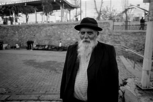 Free A black and white portrait of an elderly man standing in the streets of İstanbul, Türkiye. Stock Photo