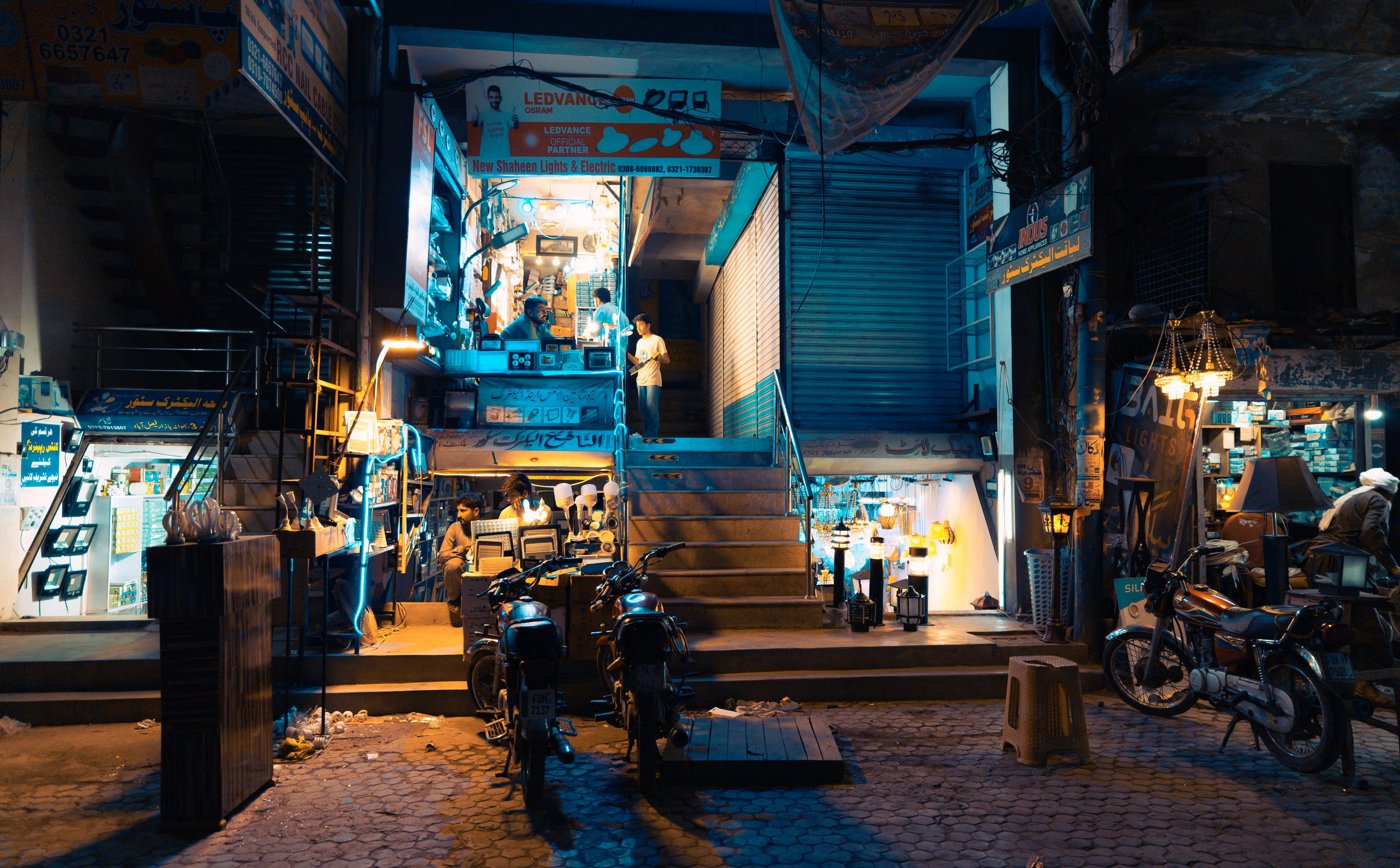 巴基斯坦费萨拉巴德的夜间街景充满活力，灯光明亮，展现了当地市场的热闹景象