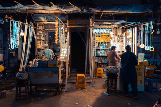 夜晚，费萨拉巴德色彩缤纷的街头市场里，当地小贩和充满活力的灯光构成了一幅生动的景象