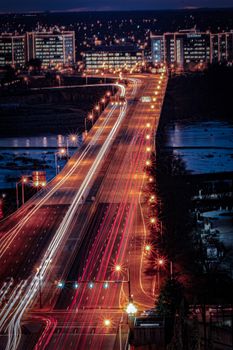 Stunning aerial night view of a city bridge with bright lights and traffic trails in Richmond, VA.