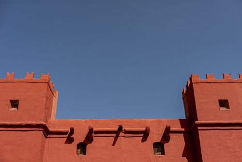 Free Red fort architecture in Malta stands out against a clear blue sky, showcasing minimalist design. Stock Photo