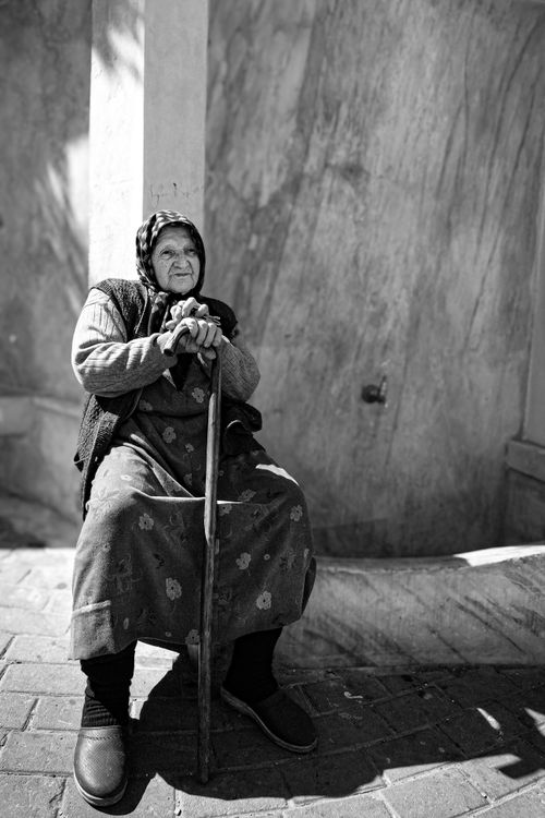 Free Black and white portrait of an elderly woman sitting on a street in İstanbul, Türkiye. Stock Photo