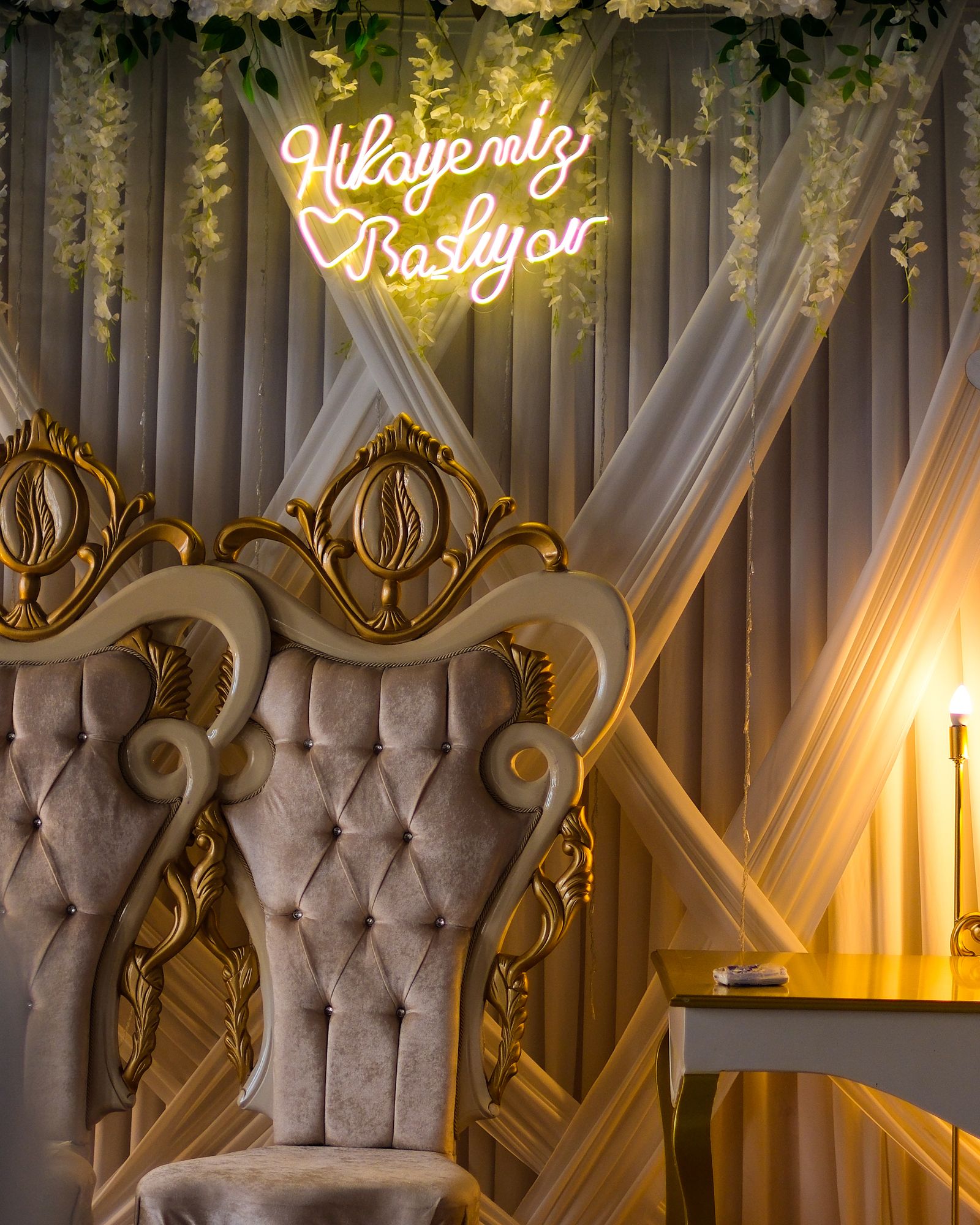 Ivory tufted throne styled with florals for a wedding reception