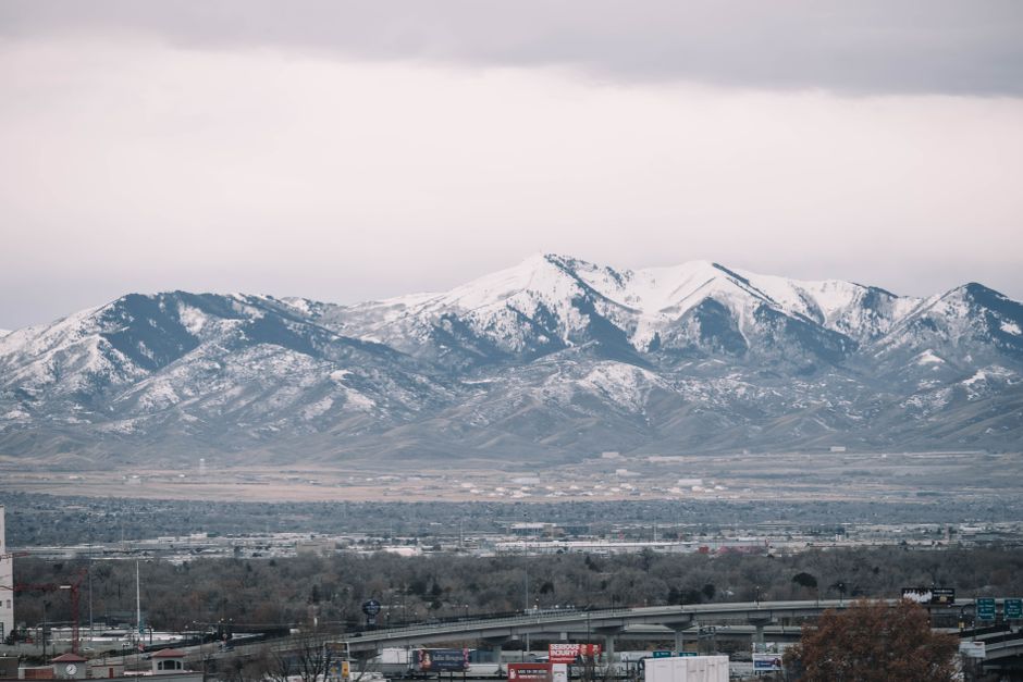 Snow-capped mountains tower over Salt Lake City's skyline, creating a stunning winter scene.