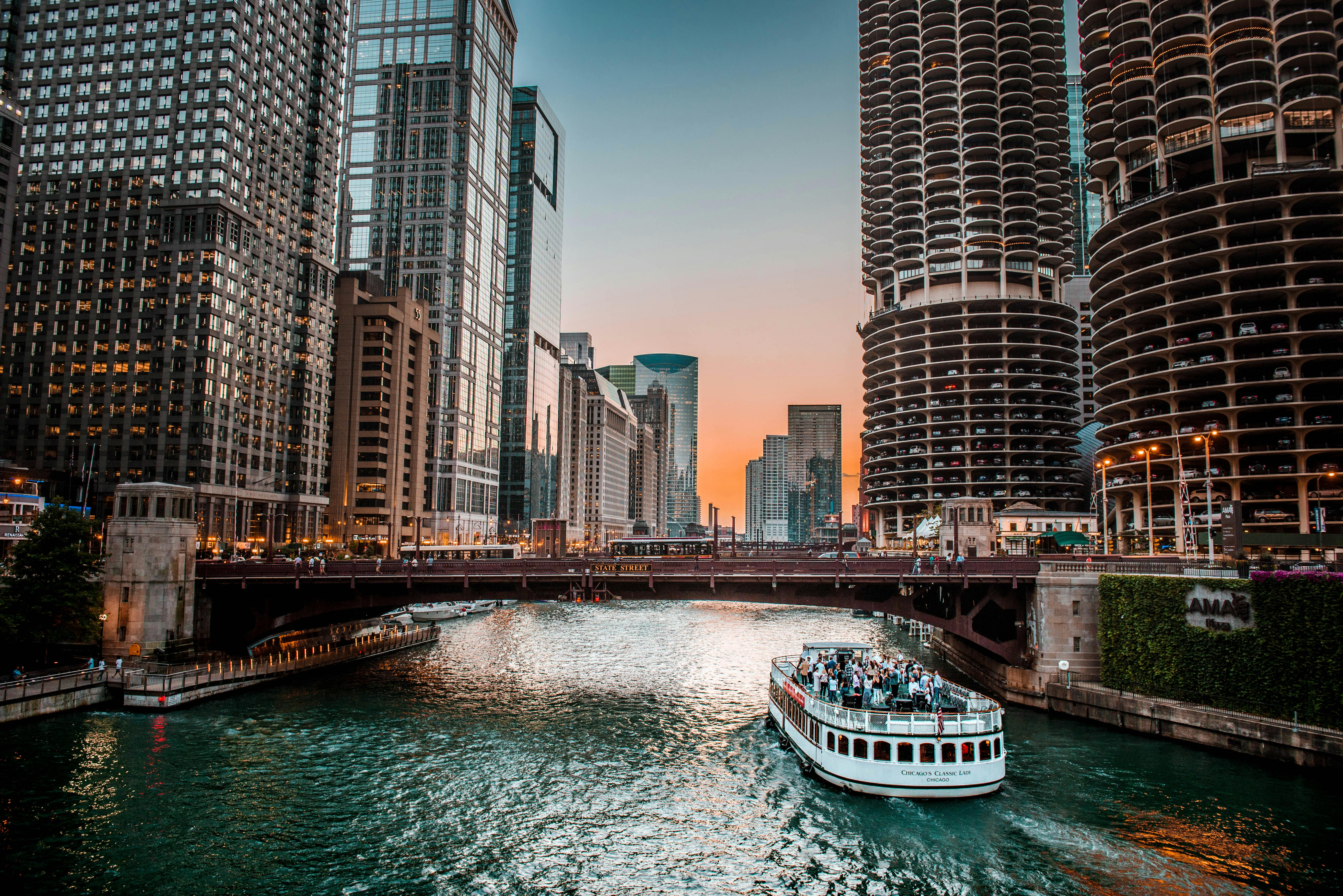 日落时分，芝加哥河上摩天大楼与船只交织的景色十分迷人