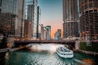 日落时分，芝加哥河上摩天大楼与船只交织的景色十分迷人