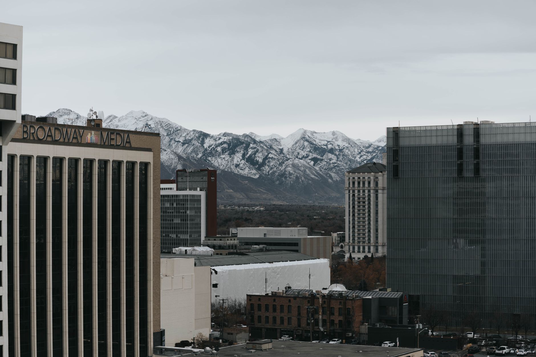 Salt Lake City's urban skyline with snow-capped mountains in the background.
