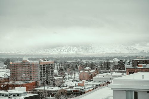 Free A winter cityscape view in Salt Lake City with snow-covered buildings and mountains in the background. Stock Photo