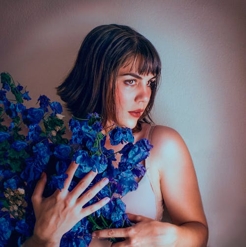 Femme Tenant Un Bouquet De Fleurs Bleues