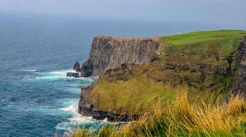 Free Stunning view of the Cliffs of Moher with grassy tops and blue ocean waves in Ireland. Stock Photo