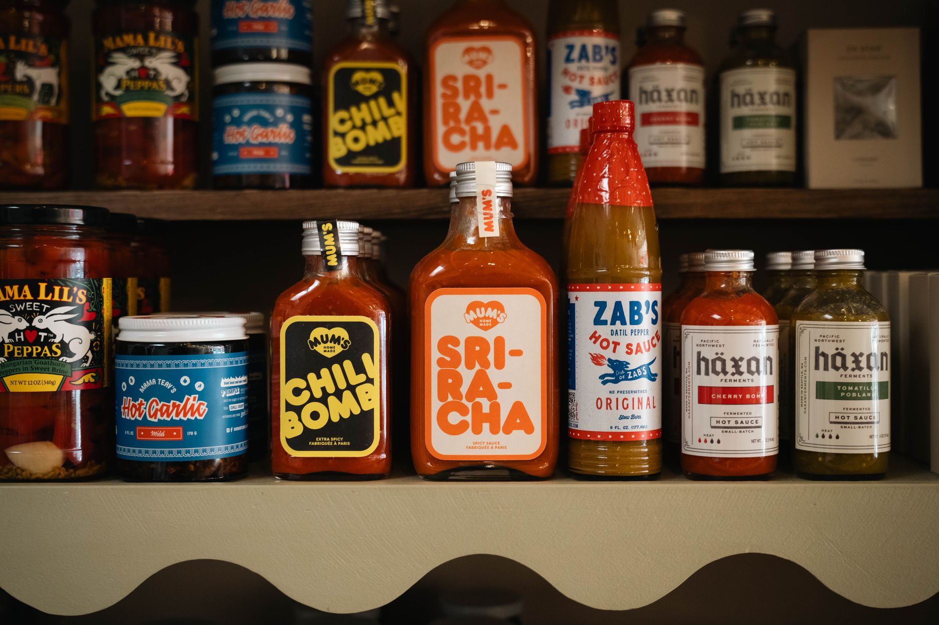 Botellas de salsa picante sriracha y cholula sobre tabla de cocina