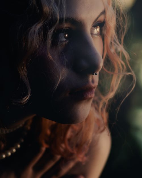Free Close-up portrait of a woman with dramatic lighting and a contemplative expression. Stock Photo