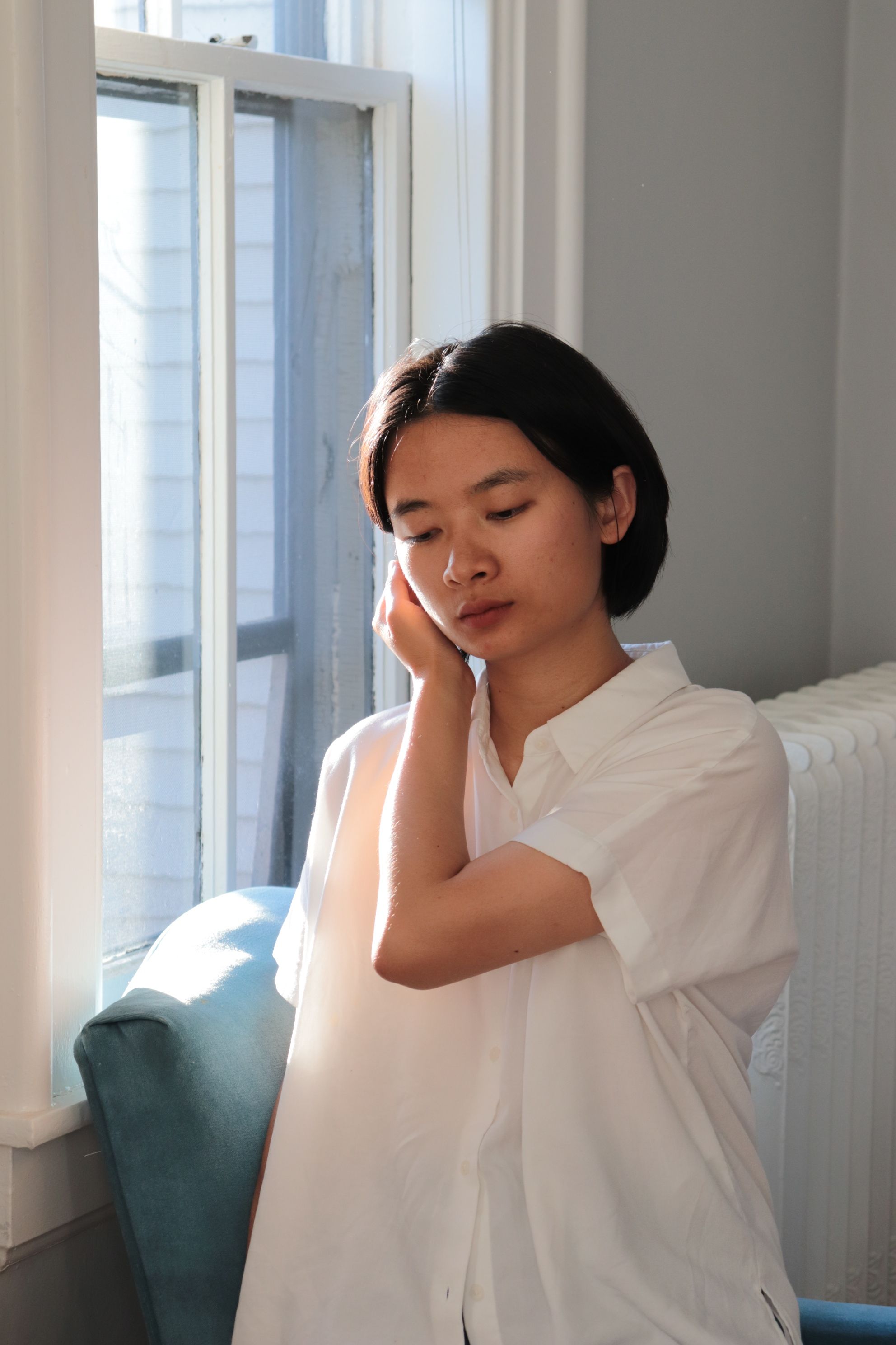 Contemplative Woman by Sunlit Window · Free Stock Photo
