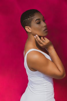 一位女子身着白色连衣裙，在充满活力的红色背景下摆姿势，肖像精致