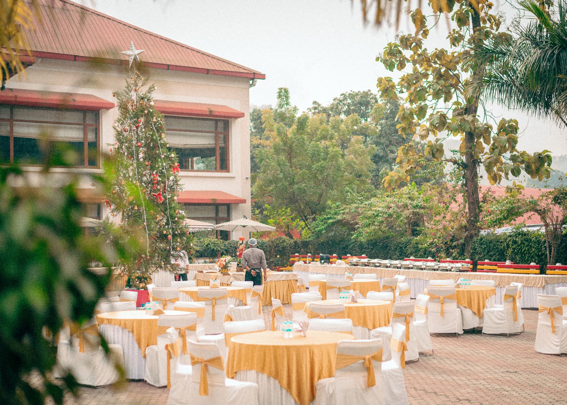 A luxurious outdoor dining setup with Christmas decorations at a resort in Assam, India.