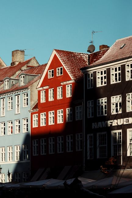 Colorful historic buildings in Nyhavn, Copenhagen under winter sunlight.