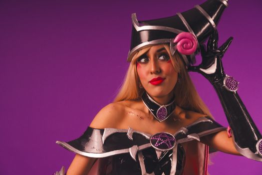 Dark Magician Girl cosplay with intricate costume and a vibrant purple backdrop.