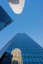 清澈的蓝天下，反光摩天大楼的向上视图展现了现代城市建筑的风貌
