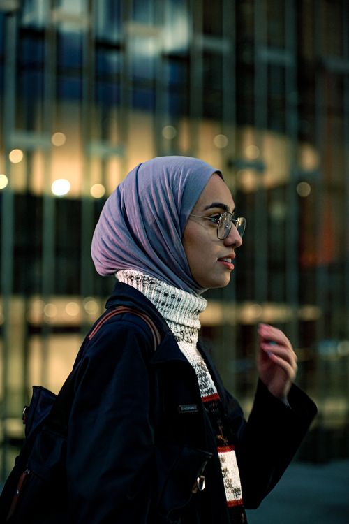 Free Stylish woman wearing a hijab in an urban setting, captured at night. Stock Photo