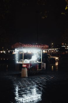 Cinematic view of a street food cart on a rainy night in Istanbul, Türkiye.
