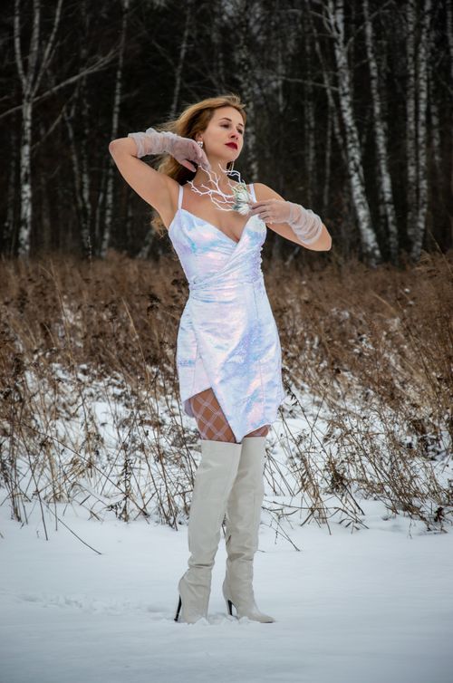 Free Elegant woman in stylish dress poses amidst snowy forest during winter. Stock Photo