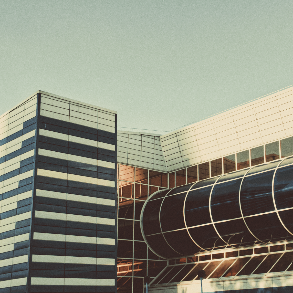 Modern industrial facade against a pale sky — photo by Primitive Spaces on Pexels