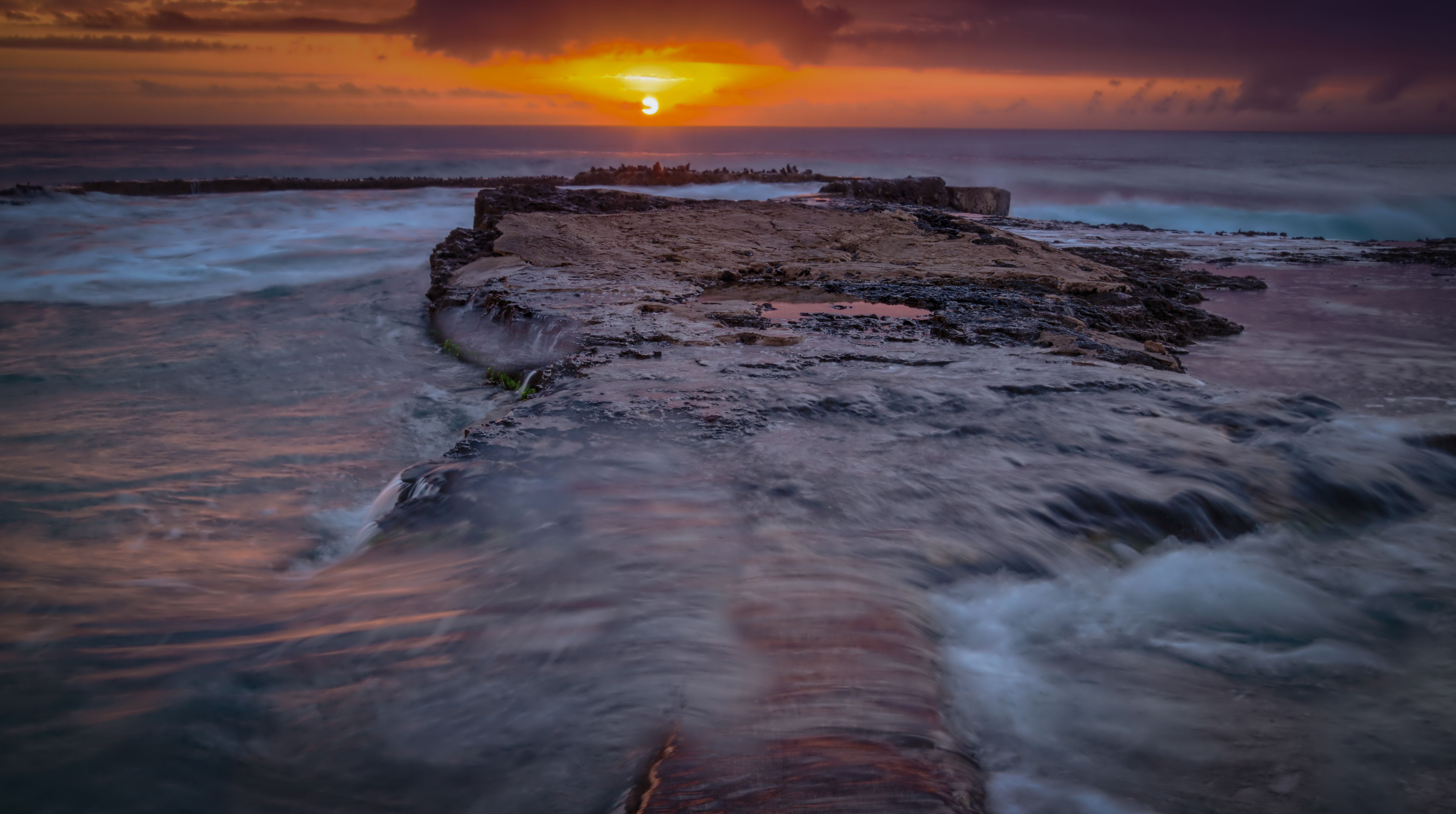 Dramatic Sunset Over Rocky Ocean Shore · Free Stock Photo