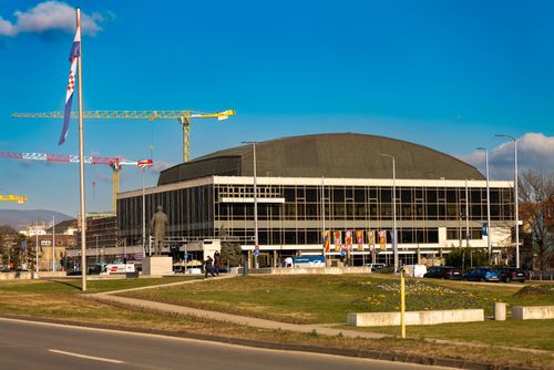 Free Dom Sportova arena in Zagreb with construction cranes and Croatian flag in the foreground. Stock Photo