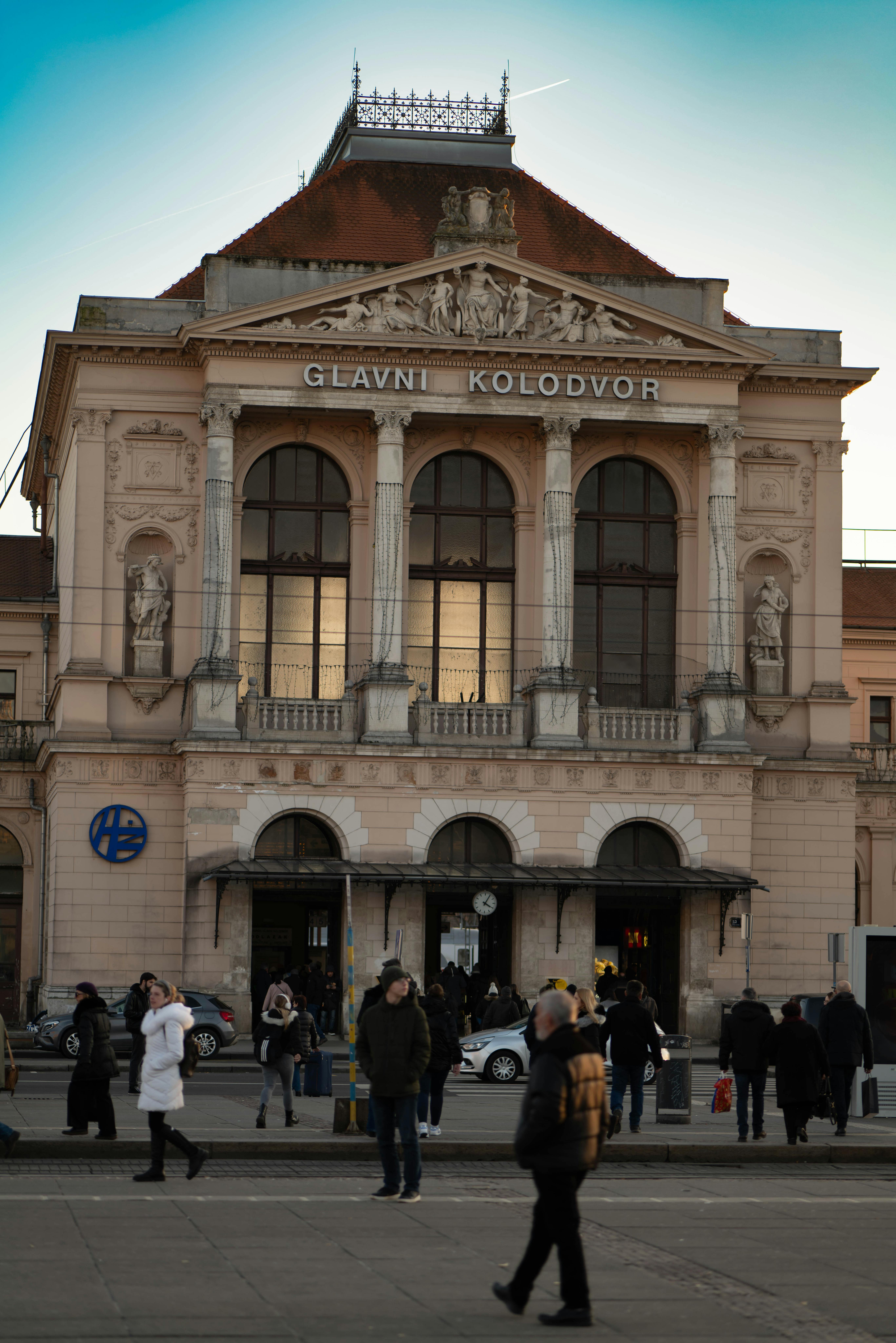 Free Zagreb Main Station, Glavni Kolodvor, with people walking in the foreground during a winter evening. Stock Photo
