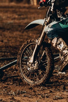 Close-up shot of a mud-splattered dirt bike in action during an off-road motocross race.