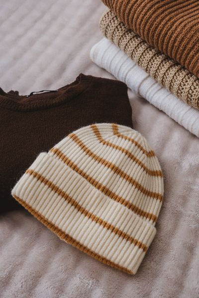 Striped knit beanie with stacked knit sweaters — photo by Gülşah Aydoğan on Pexels