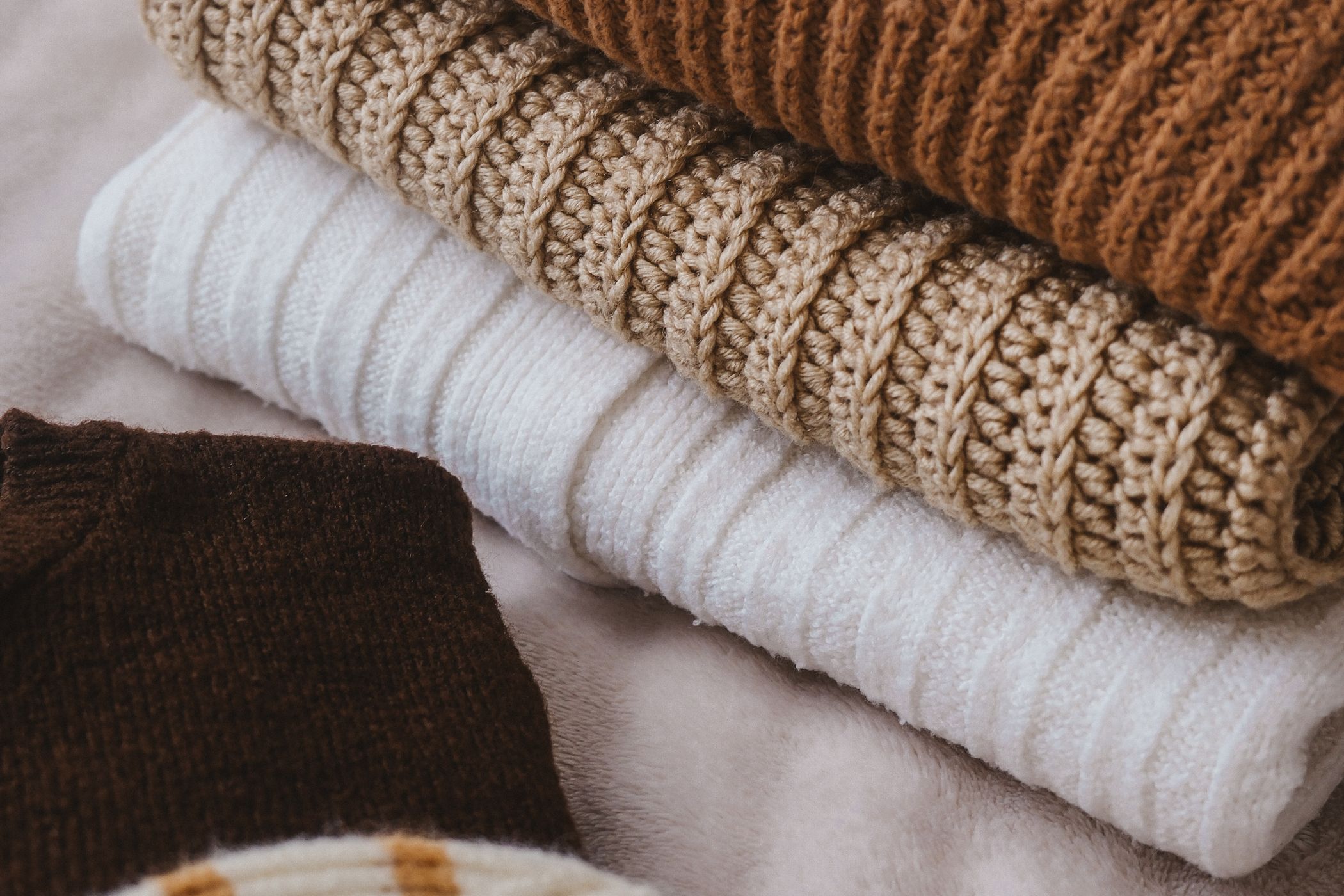 Stacked cashmere sweaters in warm neutral tones