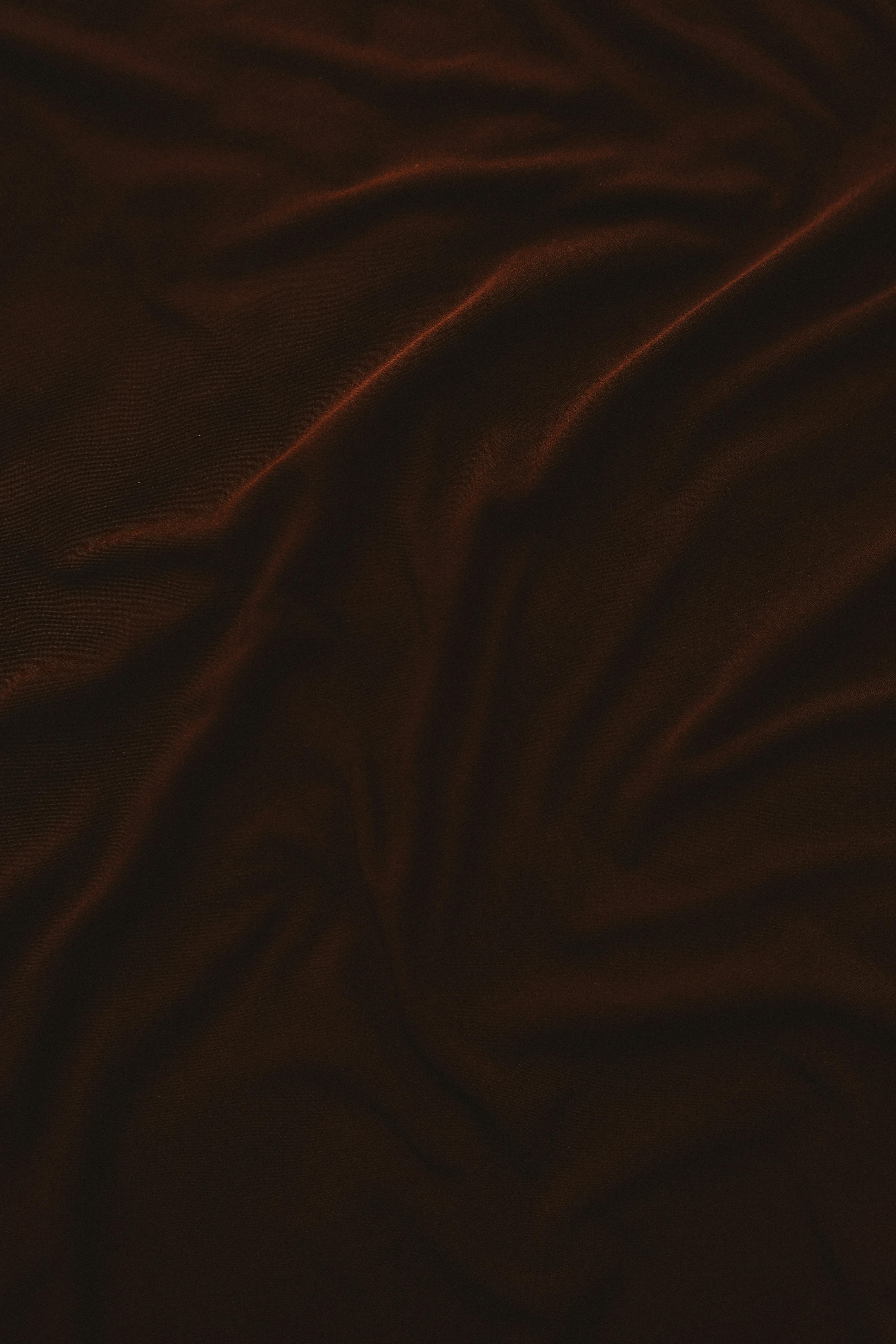 Kostenlos Reichhaltiger, dunkler Stoff mit glatten, eleganten Falten für einen strukturierten Hintergrund. Stock-Foto